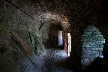 Dark tunnel looking like a prison, with light entering from the right side