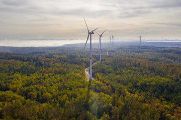 multiple wind turbines in nature colorful autumn forest