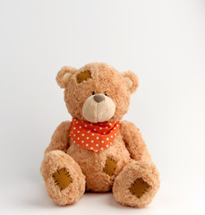 brown vintage teddy bear with patches, white background