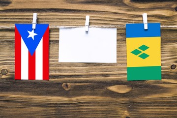 Hanging flags of Puerto Rico and Saint Vincent And The Grenadines attached to rope with clothes...