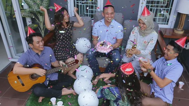 Group of friends enjoying brithday party and singing together