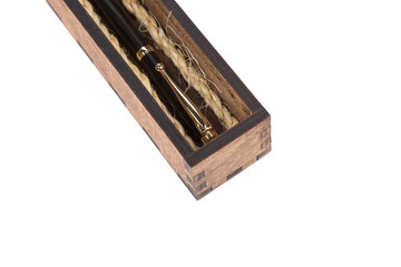 Beautiful wooden box with ballpoint pen inside on a white background.
