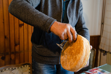 Man family housefather pouring the wine on the slava bread at home by the family table using in the...
