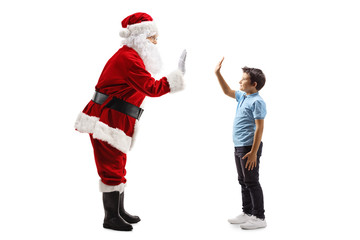 Santa Claus gesturing high-five with a little boy