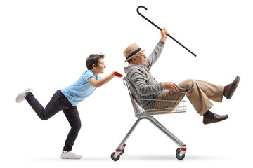Boy pushing his crazy grandfather in a shopping cart