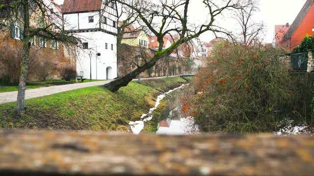 Beautiful landscape with old houses standing along the river banks covered with green plants and bushes. Art. Old town in small european town.