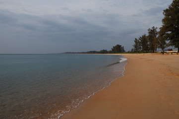 The lazy waves of Mai Khao Beach, Phuket, Thailand