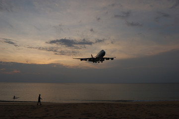 A landing plane in the evening skies over Mai Khao Beach, Phuket, Thailand