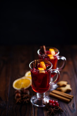 Mulled wine with aromatic spices and fruits on wooden rustic table, copy space. Traditional...