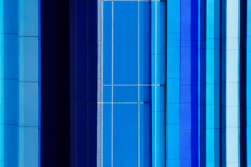 Reworked photo of windows. Abstract modern architecture of an office building with structural glazing. Wall with stripes of glass and steel pattern. Geometric background of parallel lines.