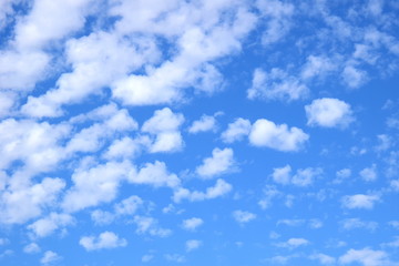 Weiße Schäfchenwolken an einem schönen Sommertag vor blauen Himmel