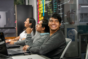  young people in boardroom and coworking shared office using computers working on computer