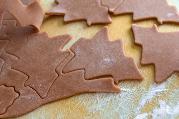 Christmas shaped gingerbread cookie from the raw dough before baking. Process of cutting forms from ginger dough