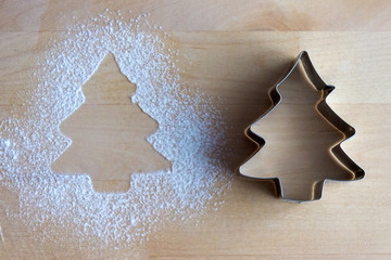 Christmas tree metal form lies on the table with four sprinkled form