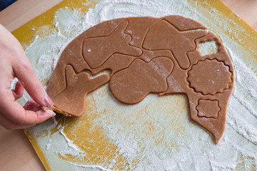 Christmas shaped gingerbread cookie from the raw dough before baking. Process of cutting forms from ginger dough