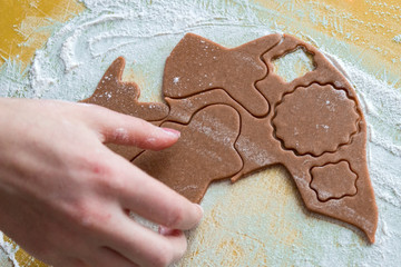 Christmas shaped gingerbread cookie from the raw dough before baking. Process of cutting forms from ginger dough