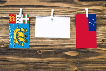 Hanging flags of Saint Pierre And Miquelon and Samoa attached to rope with clothes pins with copy...