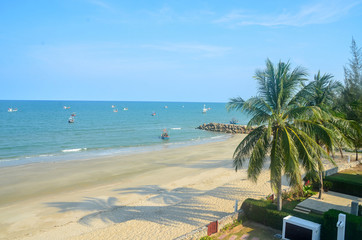 Exotic tropical vibrant coastal waterscape with palm trees in a blue sky over ocean water. Thailand.