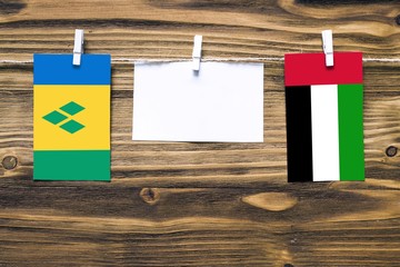 Hanging flags of Saint Vincent And The Grenadines and United Arab Emirates attached to rope with...