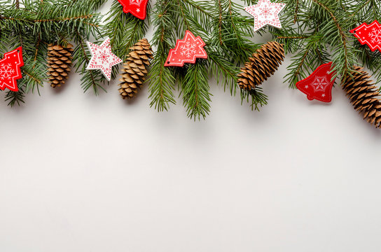 Christmas toys with fir tree branches on white background, copy space