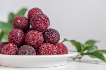Sweet and sour red fruit bayberry, before a white color background