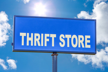 Obraz premium Thrift store sign o against a blue sky with clouds and sun