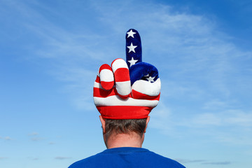 Man wearing an american patrioitic hat making an obscene gesture