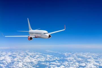 Fototapeta premium White airplane flying above cloud