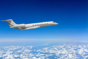 Naklejka na ściany i meble White airplane flying above cloud