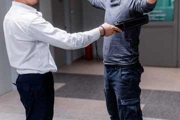 Security guard checking a man for weapons at entry