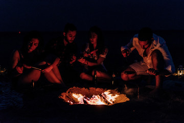 Fototapeta premium Happy friends having fun around bonfire