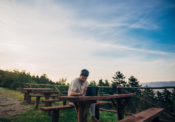 Obraz premium Businessman using a laptop computer against beautiful landscape