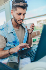 Relaxed man using laptop at airport