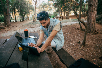 Freelance developer or designer working on laptop in the forest