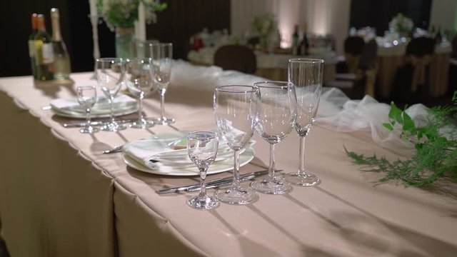 Glasses, plates, Cutlery and napkins. Decorated tables with flowers for the party. Wedding reception, birthday, anniversary