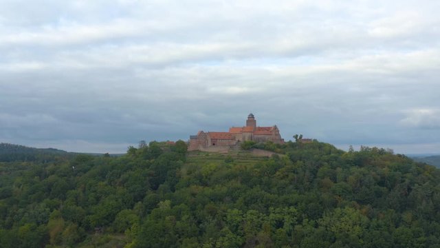 Aerial view of the castle Burg Breuberg in Germany. On a cloudy day in autumn. Descending beside the castle.