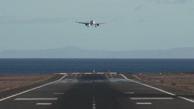 LANZAROTE, SPAIN - JUNE 23, 2019: Front view of the airplane final approach and landing, TUI Airways aircraft taxing to the runway overlooking the ocean
