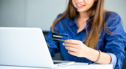 online shopping concepts. Woman hand  holding mobile phone and credit card with Payment Detail page display. using smartphone and laptop computer for online shopping
