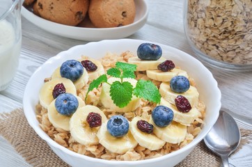 Delicious sweet healthy breakfast. Oatmeal with bananas, blueberries and cranberry.