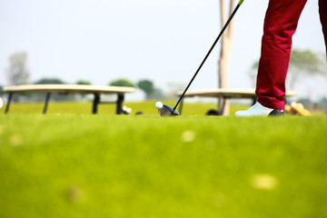  golfer holding club and hitting ball on green grass