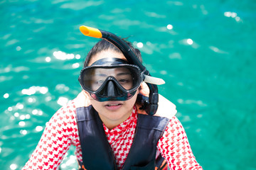 Happy snorkel girl having fun in ocean water snorkeling on Caribbean vacation in Thailand