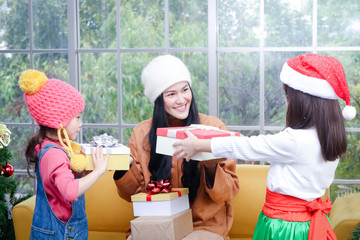 The two lovely girls are happy that the beautiful sisters give presents at Christmas. They are happy on the holiday season. Merry Christmas