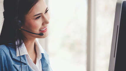 Customer support agent or call center with headset works on desktop computer while supporting the customer on phone call. Operator service business representative concept.