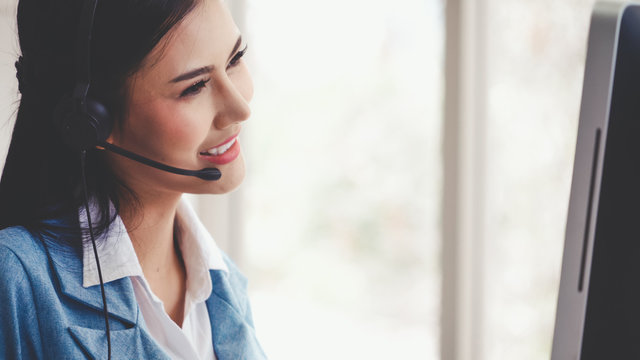 Customer support agent or call center with headset works on desktop computer while supporting the customer on phone call. Operator service business representative concept.