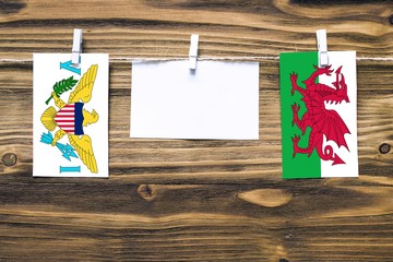 Hanging flags of United States Virgin Islands and Wales attached to rope with clothes pins with...