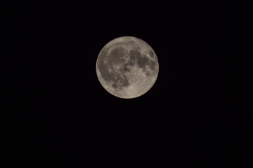 close up look of a full moon on pitch dark sky