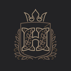 H letter logo consisting of floral pattern letters in a heraldic shield with crown.