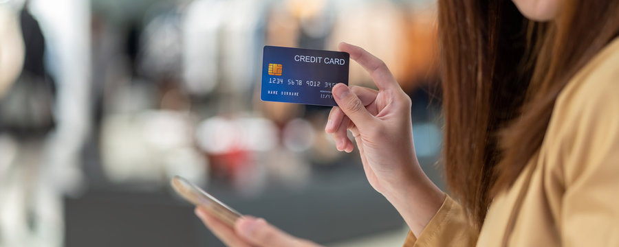 Banner Of Asian Woman Using Credit Card With Mobile Phone For Online Shopping In Department Store Over The Clothes Shop Store, Technology Money Wallet And Online Payment Concept, Credit Card Mockup