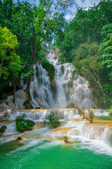 Fototapeta na wymiar Kuang Si waterfalls close to the popular town of Luang Prabang, on the Mekong River in Laos. A three level waterfall with jade green pools surrounded with lush green tropical jungle. No people.