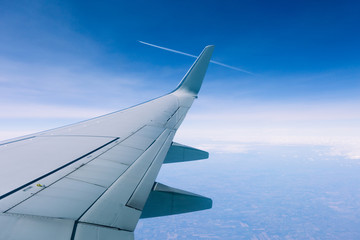 Wing of an airplane flying above the clouds